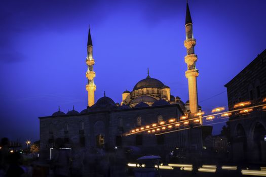 A mosque shot in the evening in Istanbul. Blured people seen in front of the mosque.