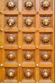 Wooden temple door with bells in Hindu temple 