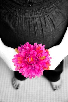 A pregnant woman in black and white with pink flower