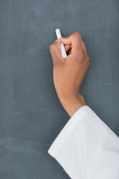 Close up of a teacher holding a white chalk in a classroom