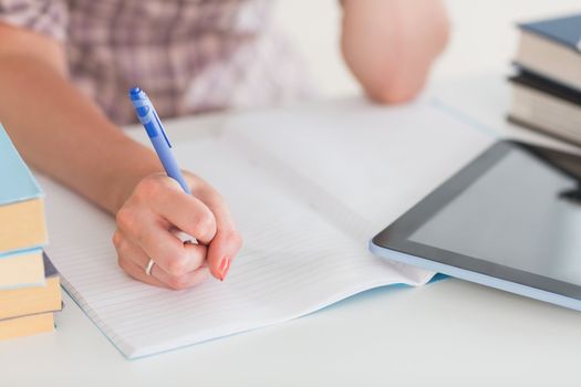 Focus on a woman writing in a living room