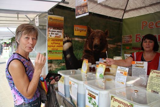 Woman Customer buying honey at the market, Moscow, Russia