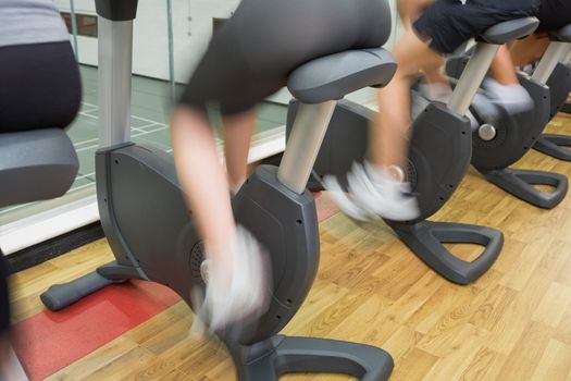 People on exercise bikes in gym with wheels turning