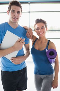 Trainer and smiling woman in gym