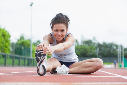 Woman stretching before race on track