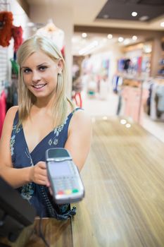 Woman showing credit card machine in clothes store