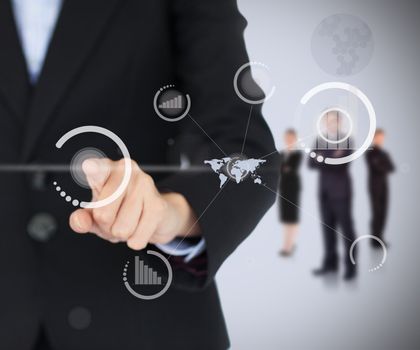 Businesswoman touching on digital screen with businesspeople standing in the background