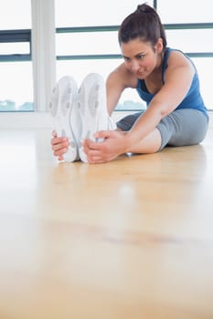 Woman stretching in yoga pose in fitness studio