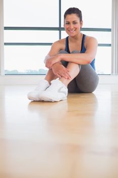 Woman smiling and sitting in fitness studio