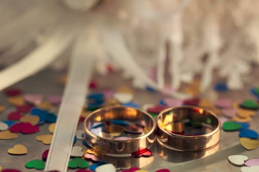 Two wedding rings on a background garters hearts scattered around