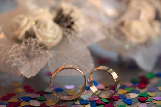 Two wedding rings on a background garters hearts scattered around