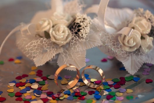 Two wedding rings on a background garters hearts scattered around