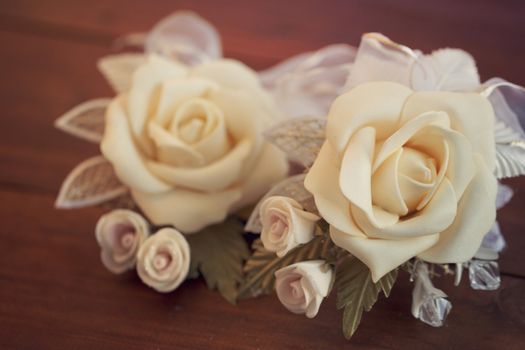 Two wedding boutonnieres of roses lie on the board