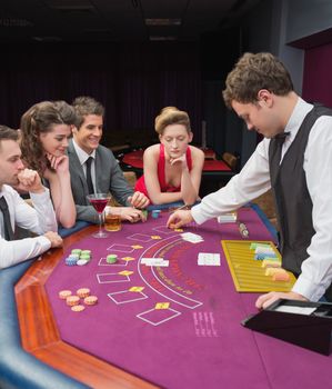 People sitting at table playing poker in casino