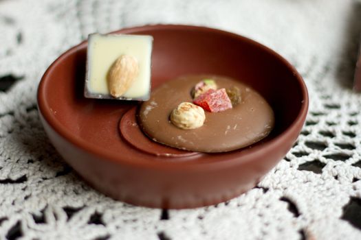 Sweets in brown saucer on knitted napkin