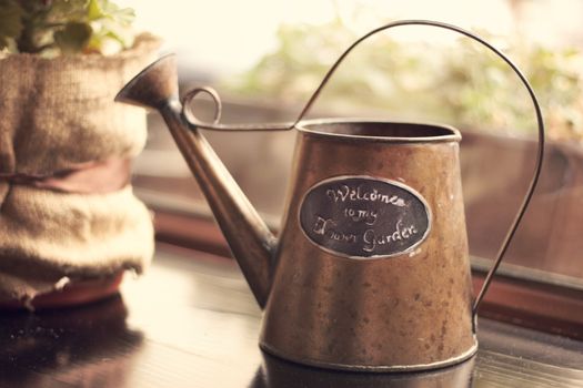 Brown iron a watering can on a windowsill