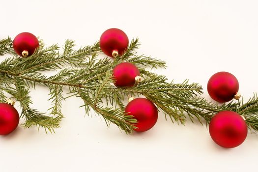 Border of red christmas garland with baubles and ribbons on white.