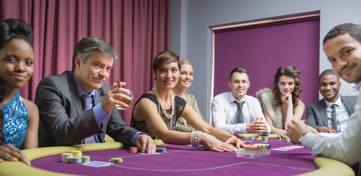 Smiling group at poker table in casino