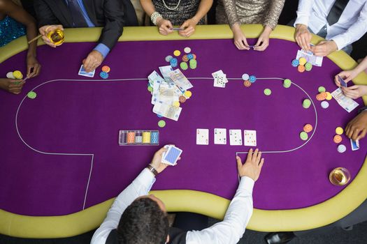 People sitting at table at the casino playing poker