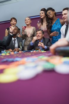 People watching roulette wheel in casino