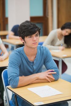 Student looking up during exam in exam hall