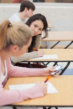 Women talking and texting during class in college