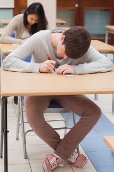 Student writing at desk in classroom