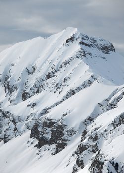 High mountains in snow, cloudy weather