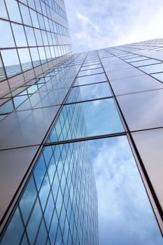 modern facade of glass and steel with reflections of the blue sky
