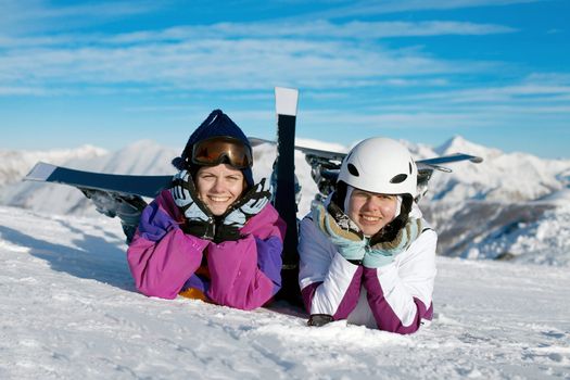 Happy female skiers resting in the snow