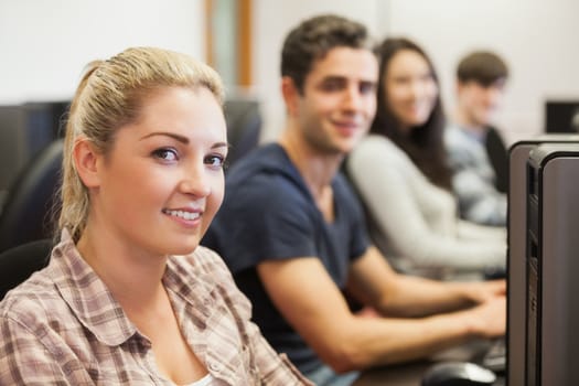 Students sitting at the computer room smiling 