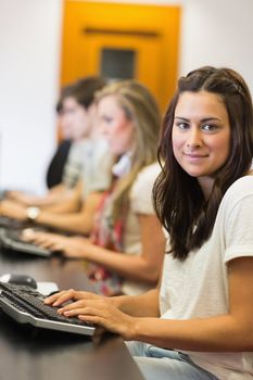 Woman sitting at the computer at the computer room while smiling in college