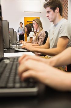 Students sitting at the computer while working in computer class in college