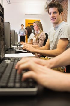 Student sitting at the computer while working in class at college