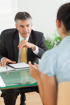 Well-dressed businessman speaking with a woman in his office 