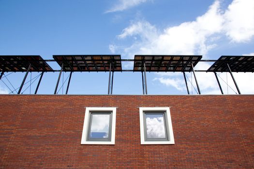 part of new house with solar panels with windows and reflections of sky