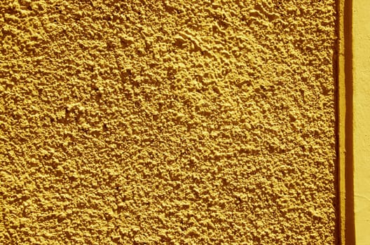Yellow-painted textured walls macro closeup. Architectural background details.