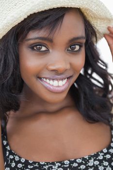 Woman wearing black dress and summer hat while smiling 