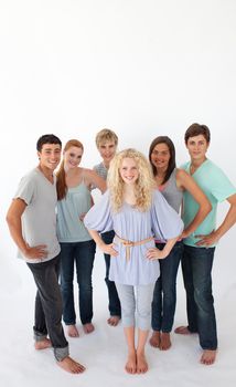 Group of smiling friends standing against white background with copy-space