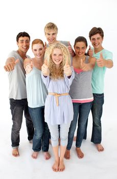 Group of teenagers standing and smiling in front of the camera with thumbs up