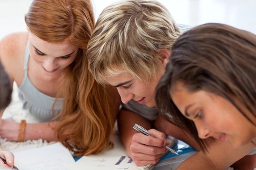 Portrait of a teenagers doing homework on the floor
