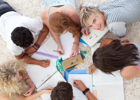 Group of Teenagers lying on the ground studying together