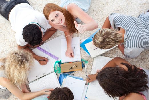 Group of Teenagers lying on the ground studying together