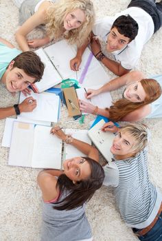 Group of Teenagers lying on the ground studying together
