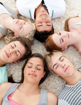 Teenagers with their heads together sleeping on the ground at home