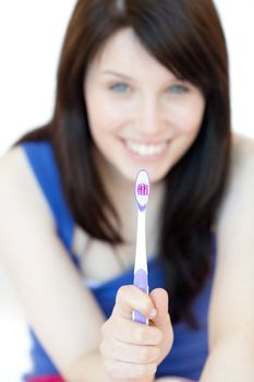 Pretty woman holding a toothbrush against a white background