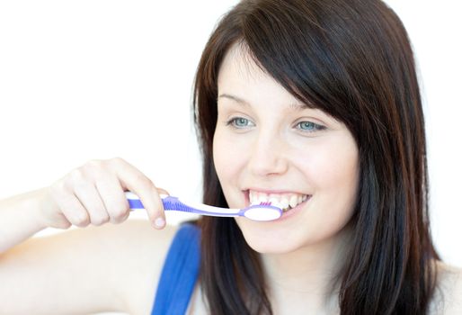 Jolly woman brushing her teeth against a white background