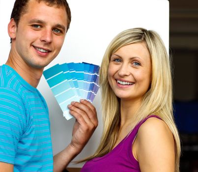 Couple with colour samples to paint new house. Concept of decoration