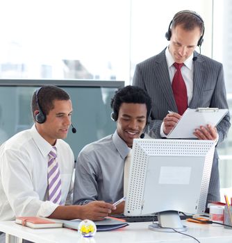 Manager and businessmen working in call center with a headset on