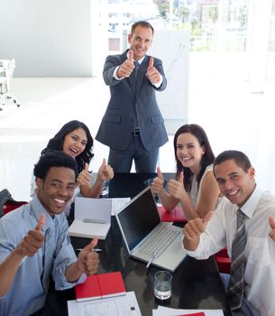 Happy business team in a meeting with thumbs up